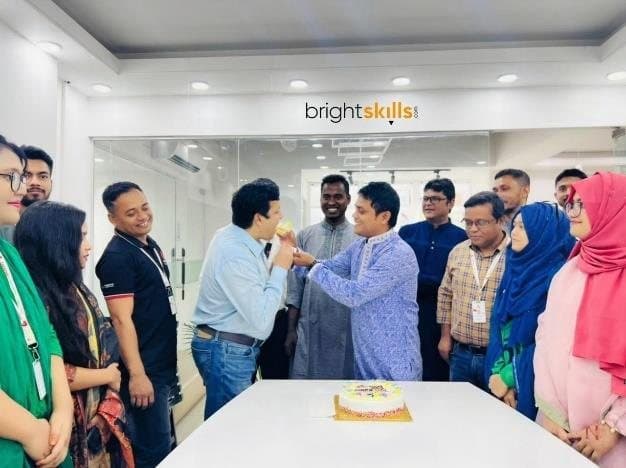 Bright Skills team members celebrating record Eid sales with cake in their office